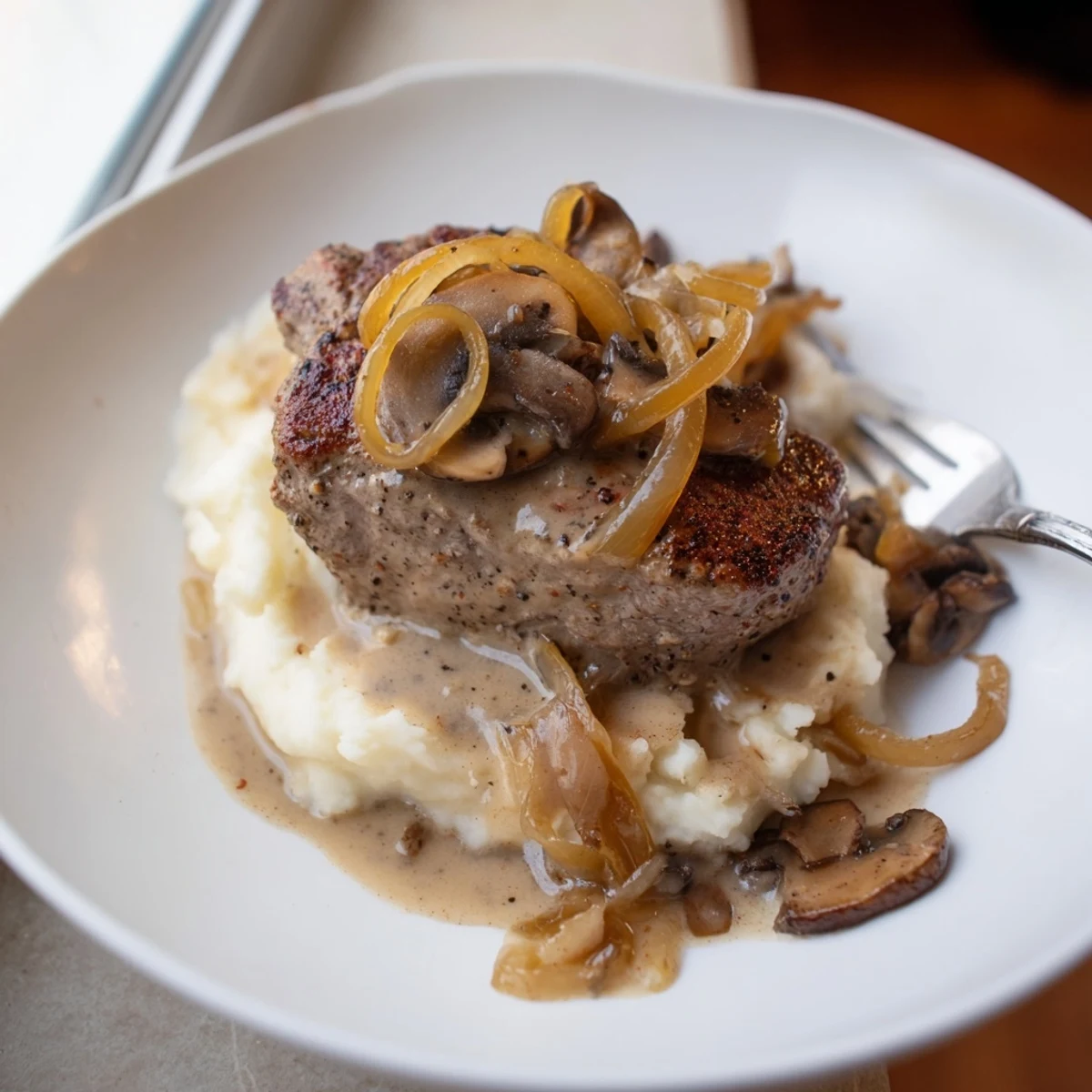 Hearty Country Style Smothered Cube Steak Recipe simmering in savory beef broth and onions
