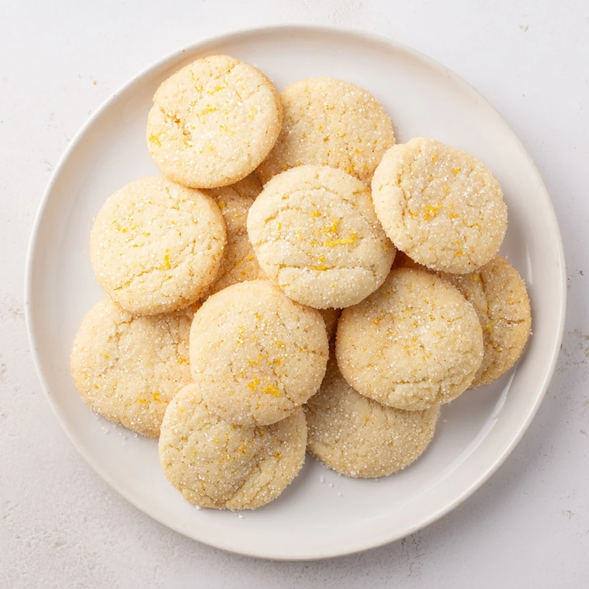 Stack of soft chewy lemon cookies with bright citrus glaze on wooden cutting board