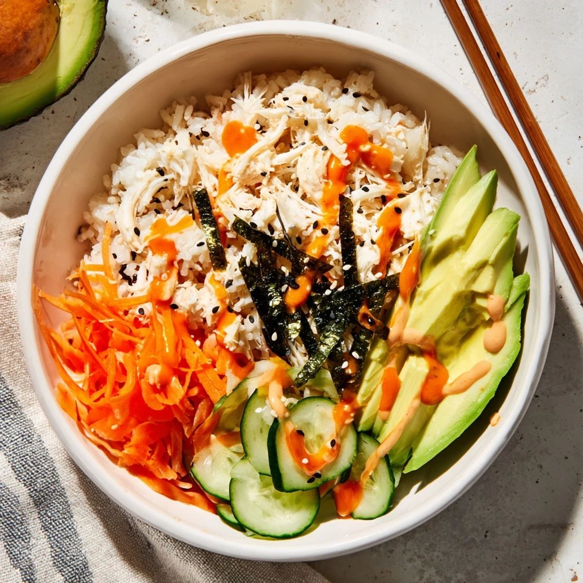 Vibrant sushi bowl featuring seasoned rice, imitation crab, sliced avocado, and crunchy vegetables
