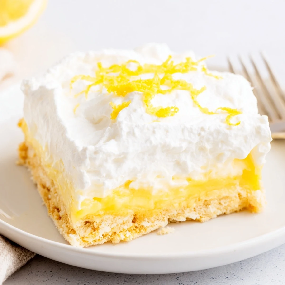 Lemon Lush Cake with creamy lemon layer and fluffy whipped topping, chilled.