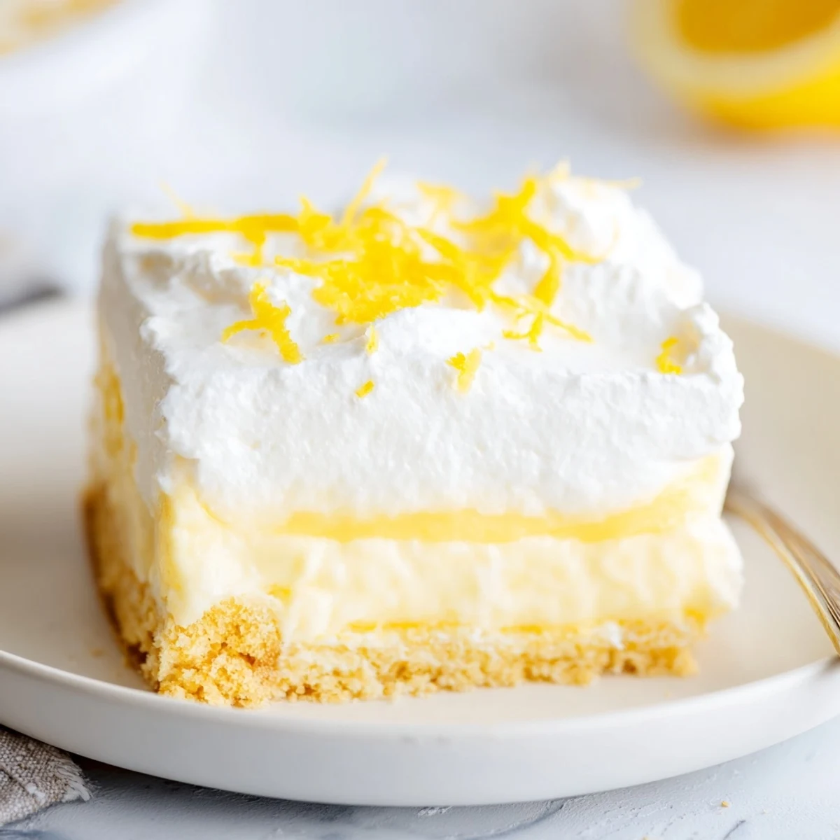 Sliced Lemon Lush Cake showing crisp cookie crust and zesty lemon aroma.