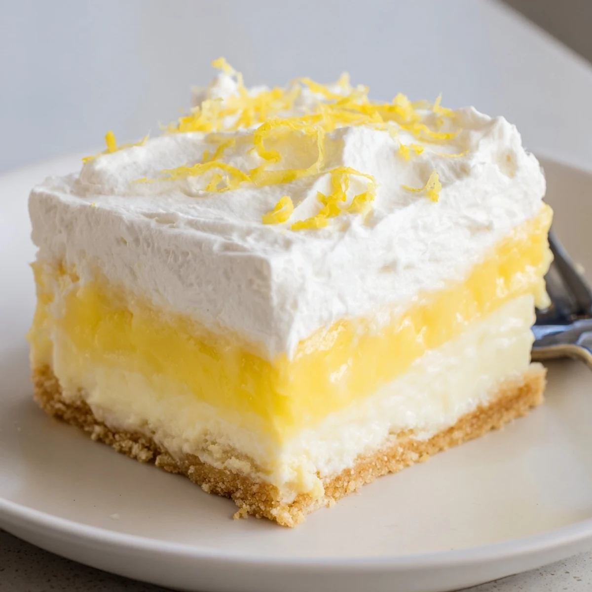Generous squares of Lemon Lush Cake topped with lemon zest, perfect with tea.