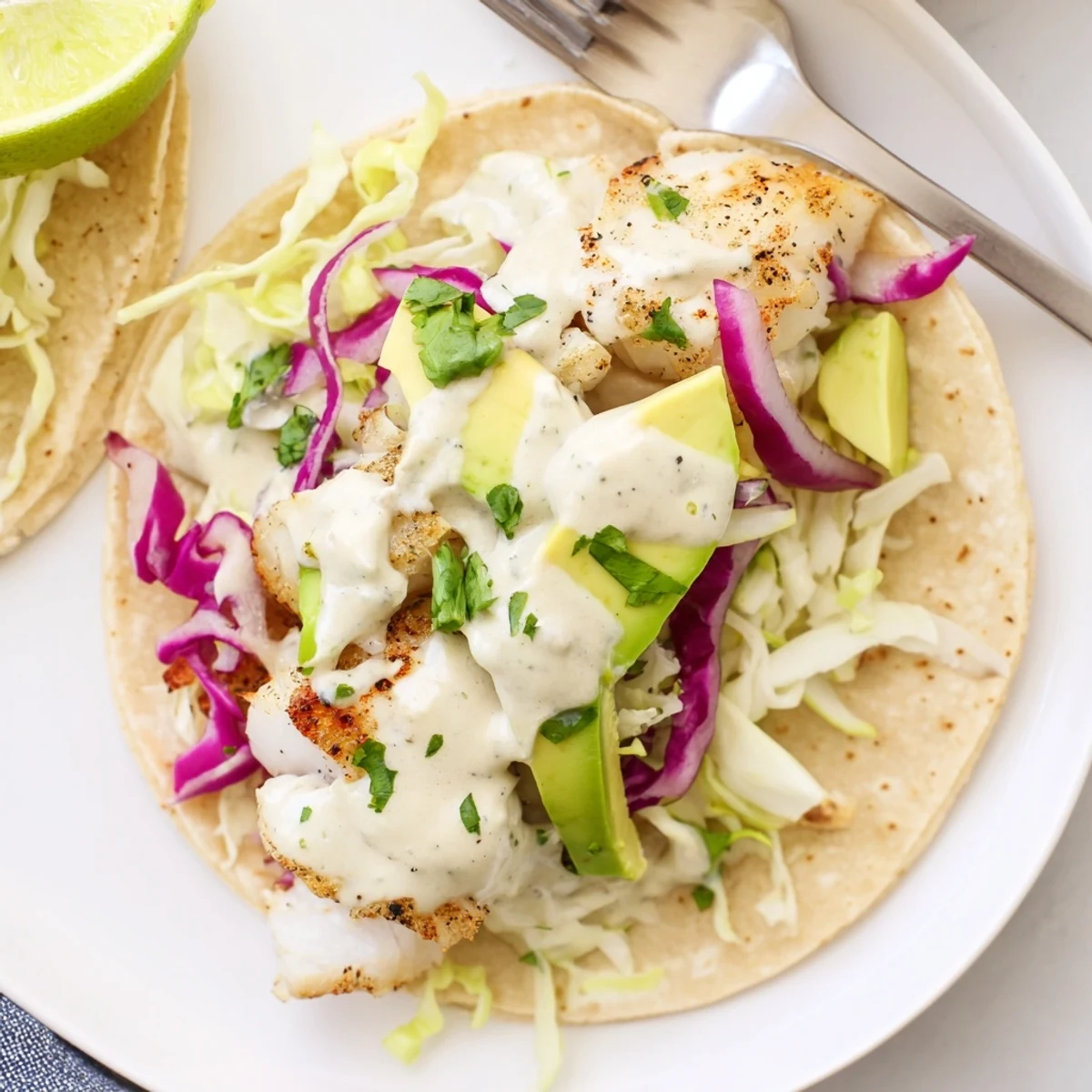 Sheet-pan dinner: Baked Cod Fish Tacos with Creamy Cilantro Lime Sauce, lime wedges.