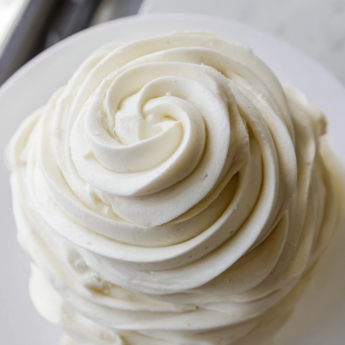 Glossy Italian Meringue Buttercream piped into elegant rosettes on a celebration cake