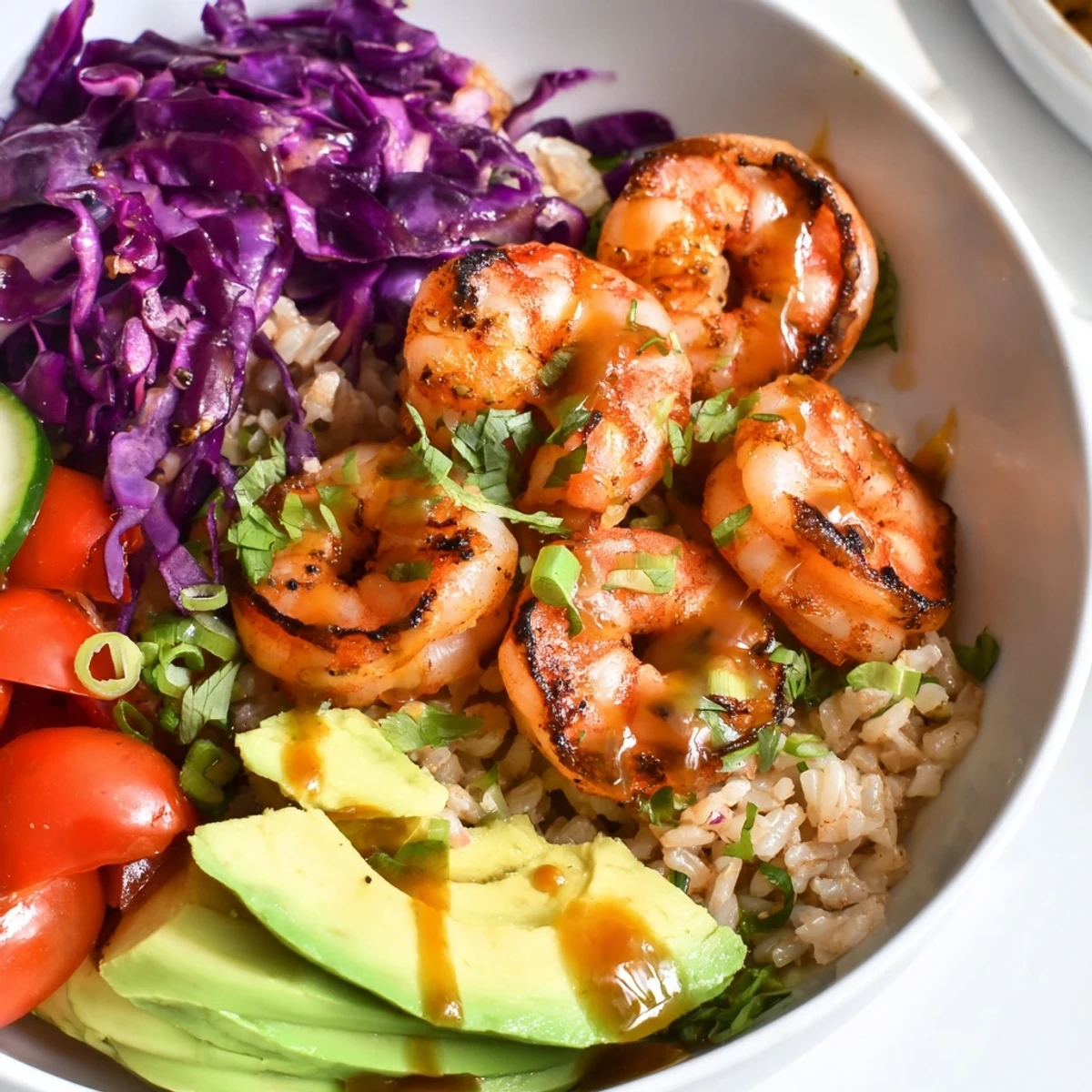 Colorful shrimp grain bowl drizzled with zesty honey lime dressing served warm
