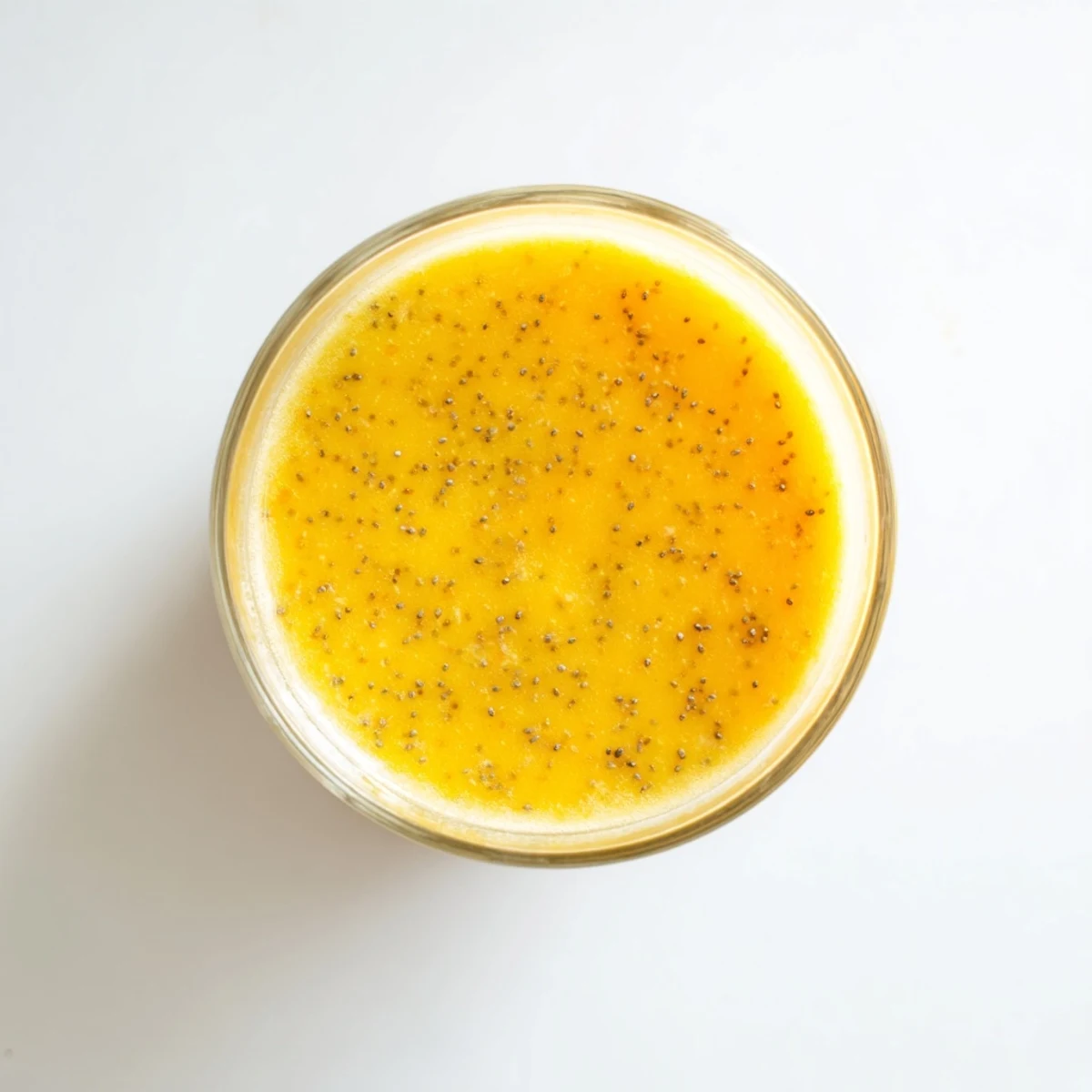 Vibrant Tropical Sunrise Protein Smoothie poured into two glasses with swirls of golden orange color and tropical fruit chunks visible throughout the thick creamy drink