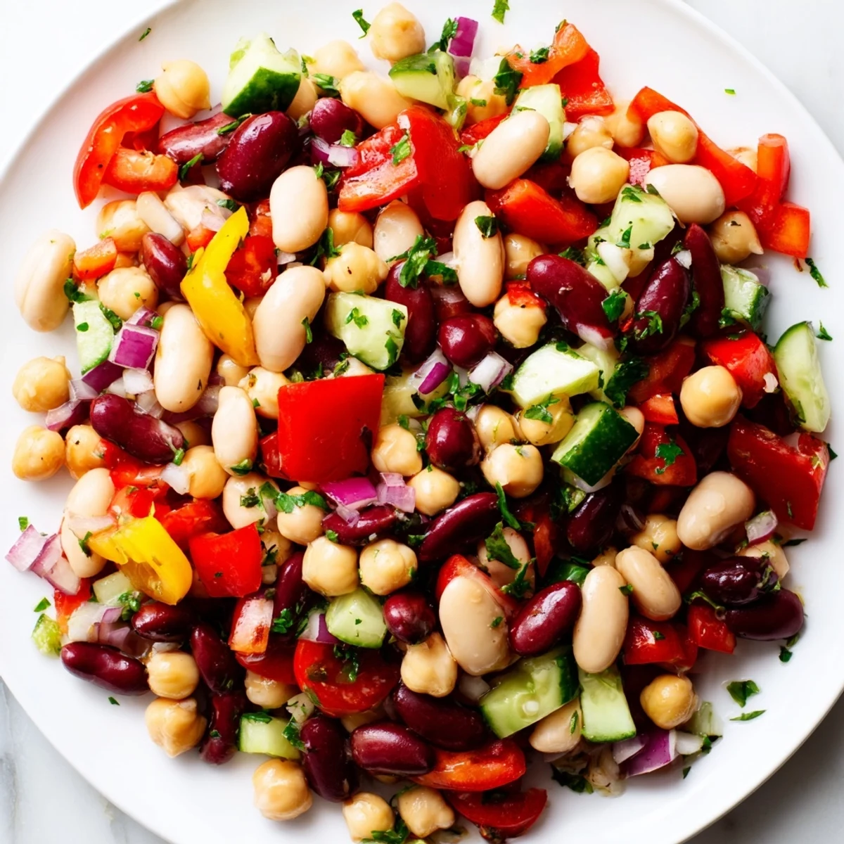 Colorful Italian Bean Salad topped with fresh herbs and a glossy vinaigrette