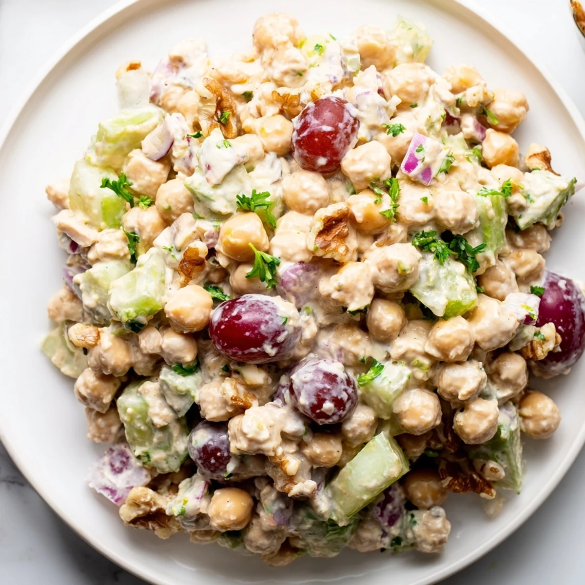 Creamy vegan chicken salad piled on toasted bread with crisp celery and fresh herbs