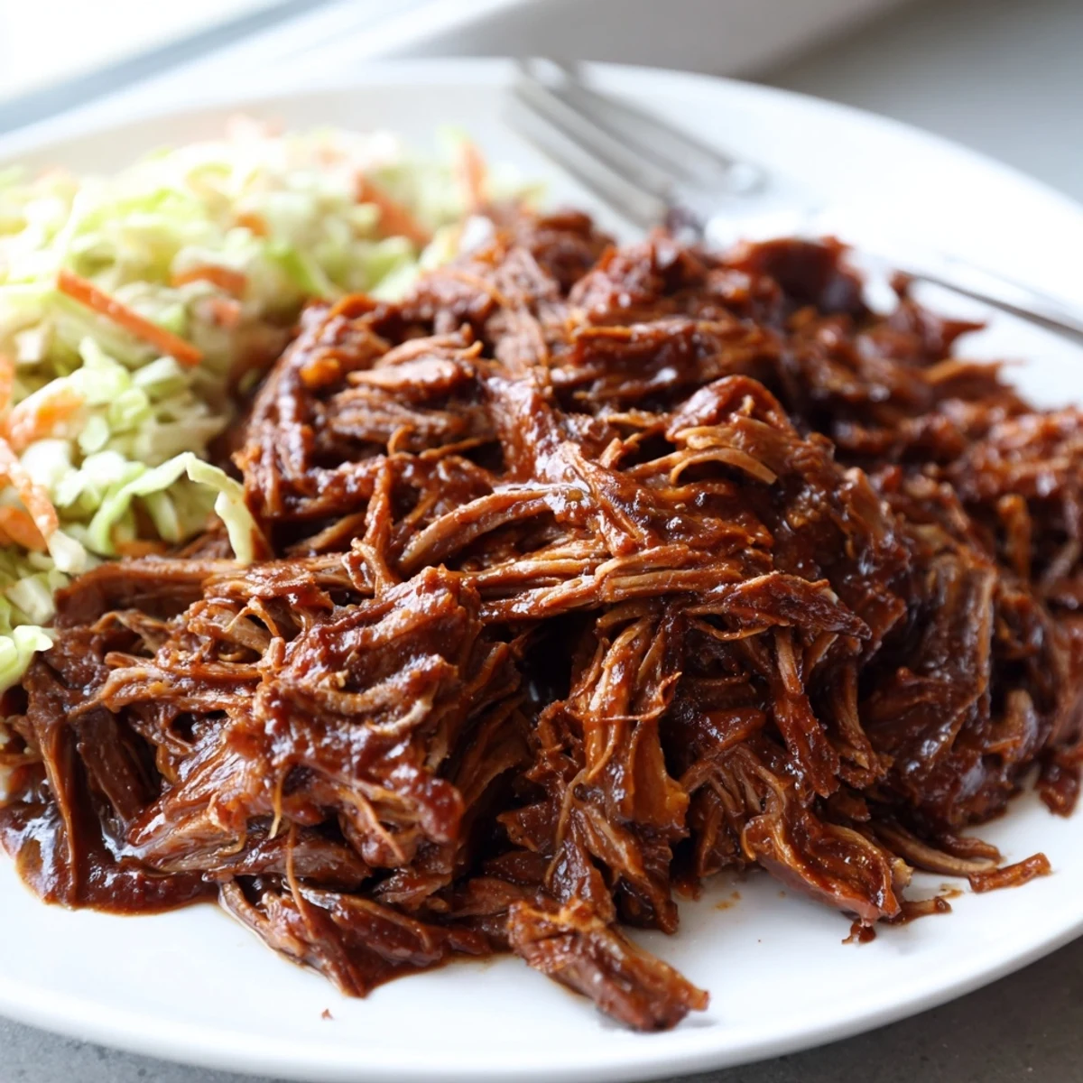 Shredded Slow Cooker BBQ Pulled Beef fork-tender and coated in sticky barbecue glaze