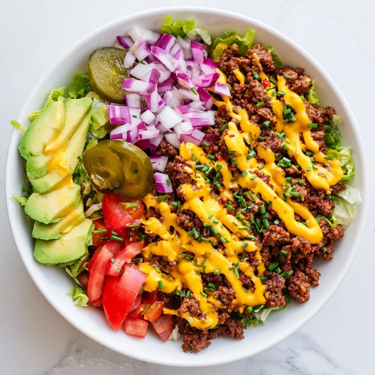 Colorful burger bowls with seasoned ground beef, melted cheddar, and fresh avocado slices