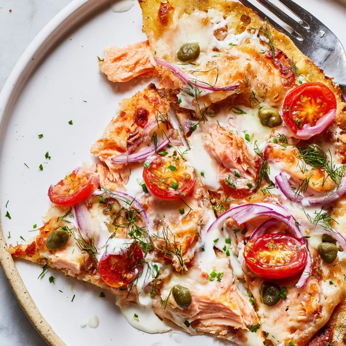 Crispy leftover salmon tortilla pizza with melted mozzarella and fresh dill garnish