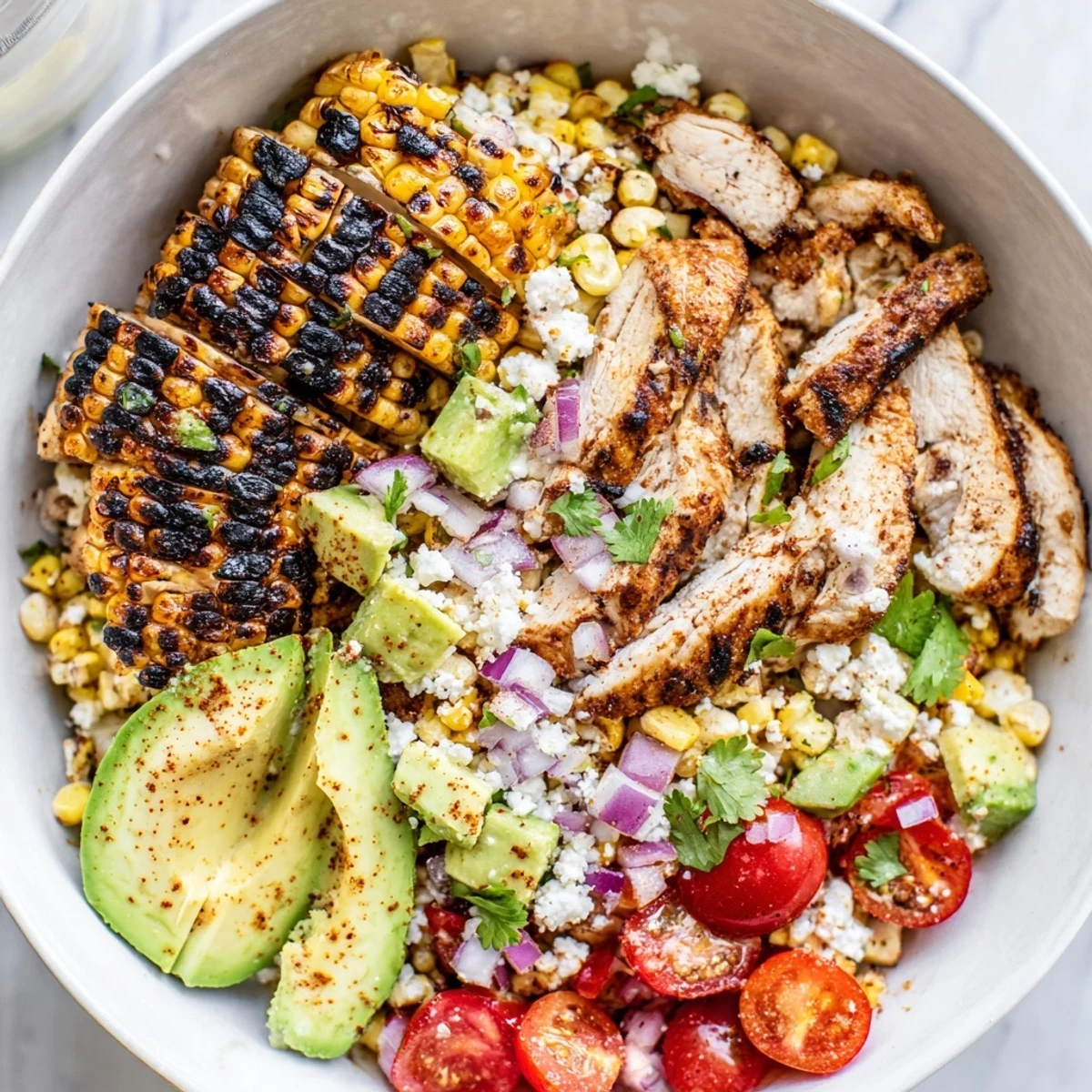 High Protein Chicken Street Corn Salad in a bright bowl topped with crumbled cotija cheese