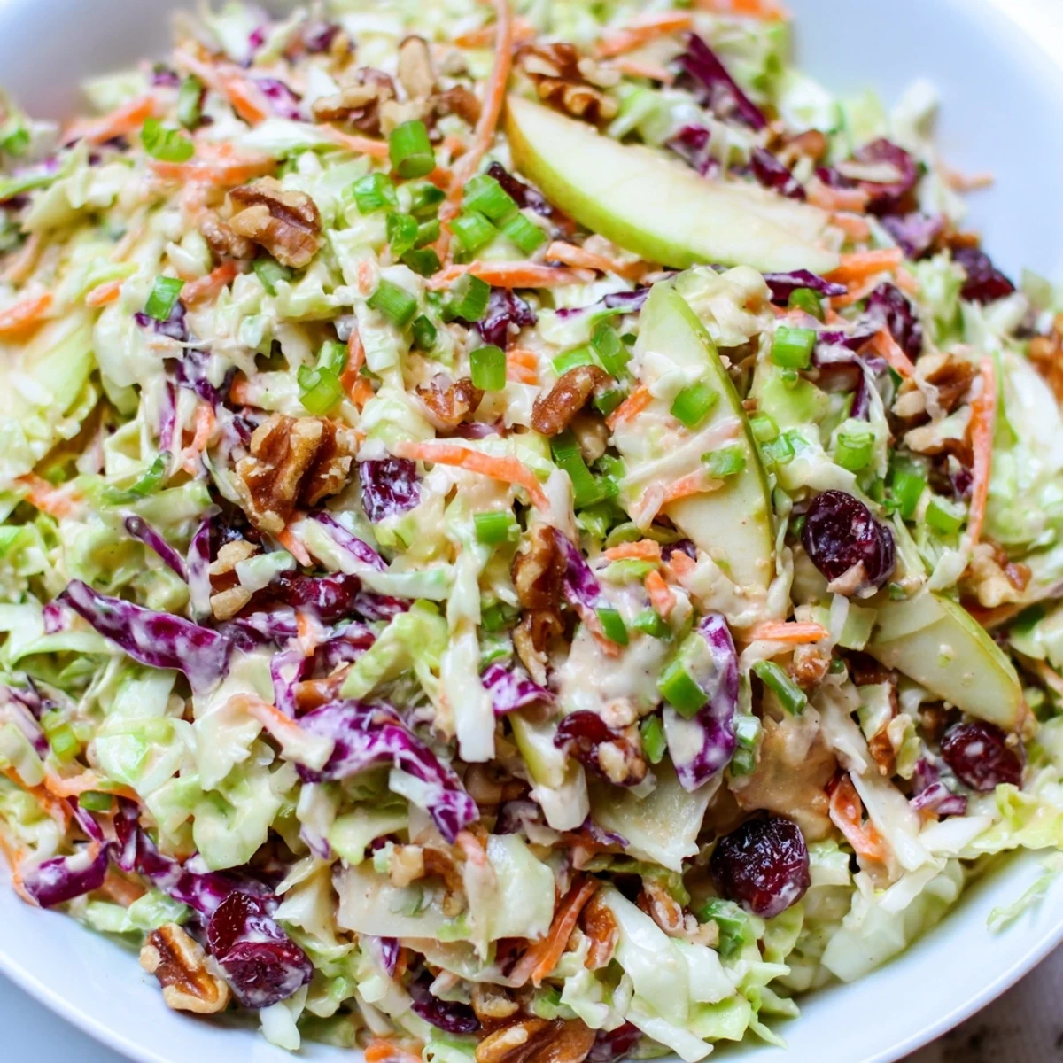 Crisp cranberry apple coleslaw topped with chopped walnuts and a creamy dressing.