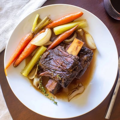 Close-up of savory Apple Cider Braised Short Ribs, browned and juicy in a Dutch oven.
