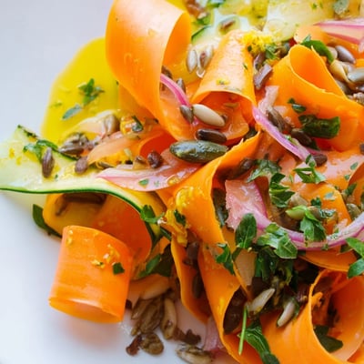 Vibrant carrot ribbons tossed in tangy lemon-orange dressing, perfect for light meals.  